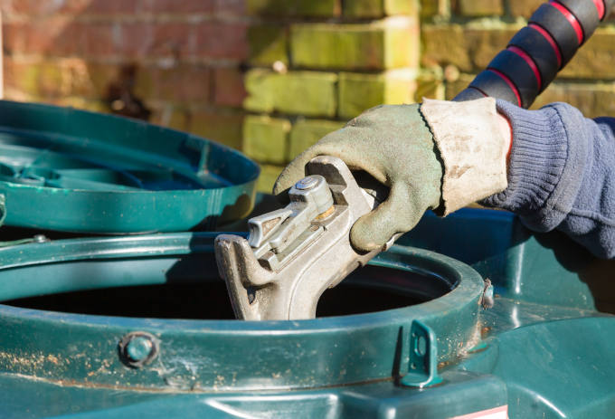 Closeup of man filling a bunded oil tank with domestic heating oil